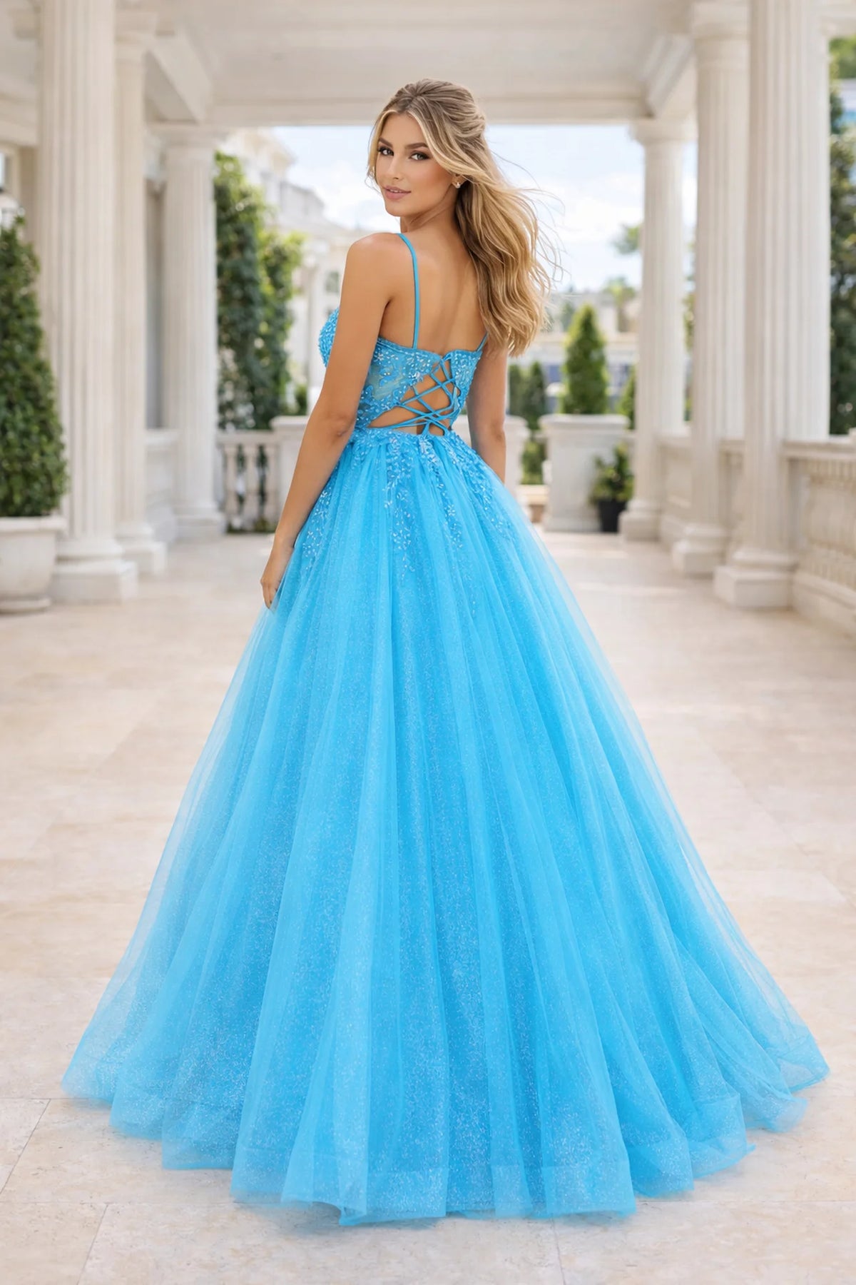 Spaghetti strap beaded lace ball gown with plunging neckline, glitter tulle skirt, pockets, and lace-up back.